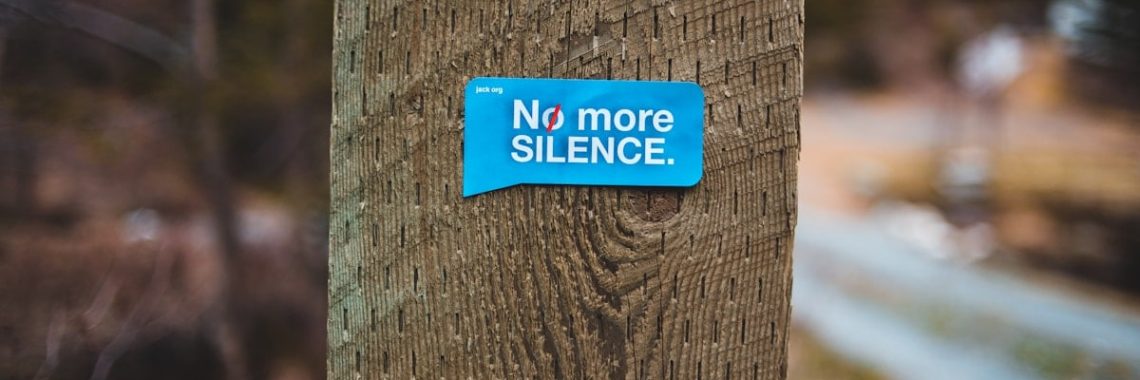 a blue sticker that is on a wooden post
